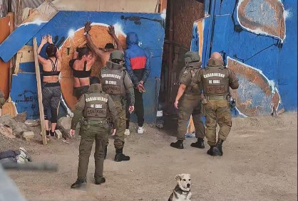 Carabineros de Chile de la sección Centauro custodian a personas detenidas contra el muro del ruco durante el operativo en avenida Pérez Zujovic.